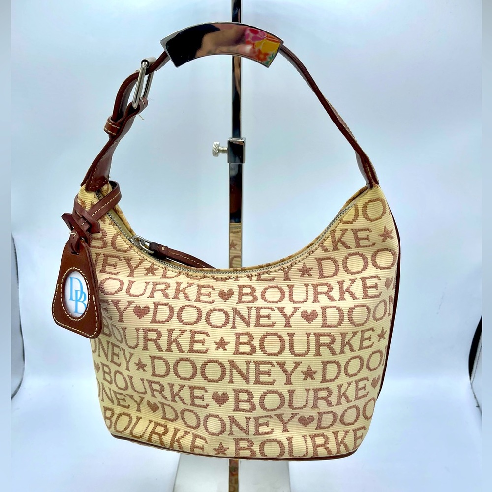 A DOONEY & BOURKE MONOGRAM PURSE OF  COATED COTTON WITH LEATHER ACCENTS.